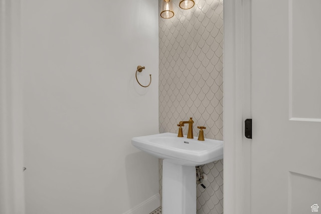 bathroom featuring baseboards and a sink