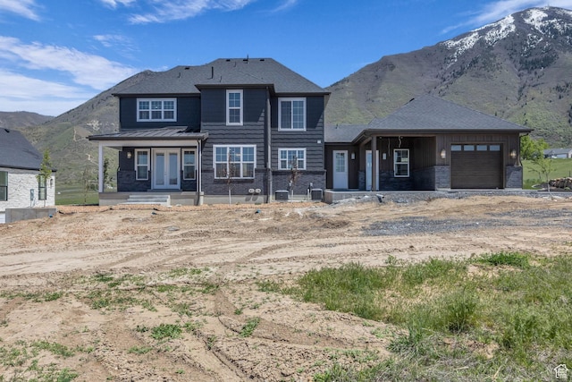 view of front of property featuring board and batten siding, an attached garage, a mountain view, and driveway