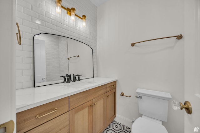 bathroom featuring toilet, baseboards, and vanity