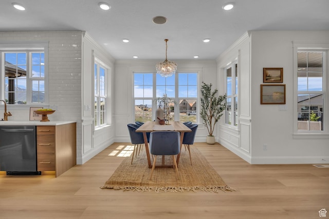 dining room with a decorative wall, light wood-type flooring, visible vents, a chandelier, and baseboards