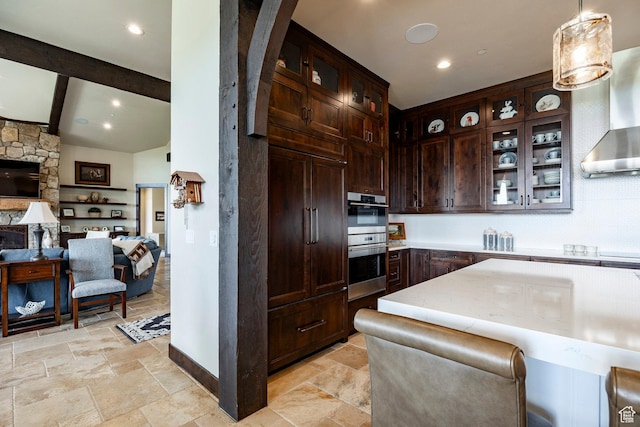 787 N Red Ledges Blvd, Heber City, UT 84032 - kitchen with beam ceiling, stainless steel double oven, open floor plan, stone tile floors, and dark brown cabinetry