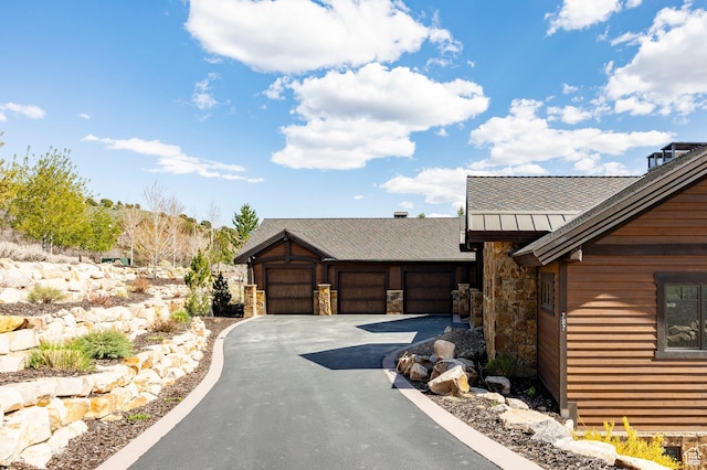 787 N Red Ledges Blvd, Heber City, UT 84032 - view of front facade with stone siding, metal roof, a shingled roof, driveway, and a standing seam roof