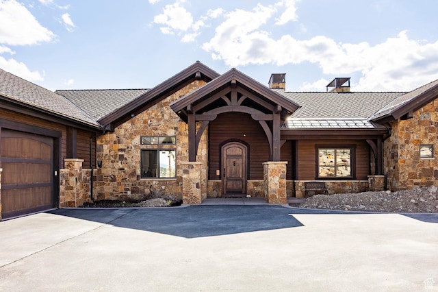 787 N Red Ledges Blvd, Heber City, UT 84032 - view of exterior entry with stone siding, driveway, metal roof, a chimney, and a standing seam roof