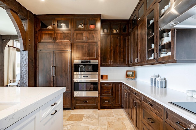 787 N Red Ledges Blvd, Heber City, UT 84032 - kitchen with paneled built in refrigerator, stainless steel double oven, stone finish floor, arched walkways, and white cabinets