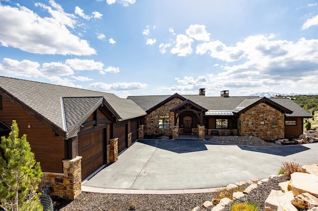 787 N Red Ledges Blvd, Heber City, UT 84032 - chalet / cabin with a chimney, an attached garage, a shingled roof, concrete driveway, and stone siding