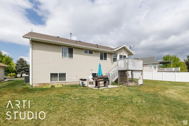 rear view of house featuring a yard, fence, a patio area, stairs, and a deck