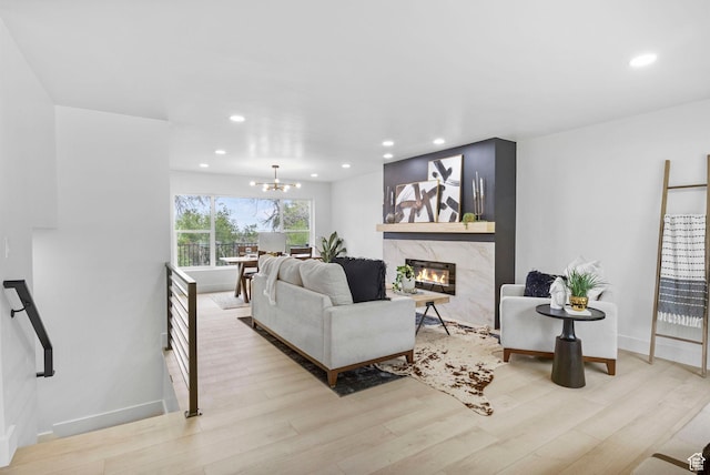 living room with recessed lighting, a high end fireplace, and wood finished floors