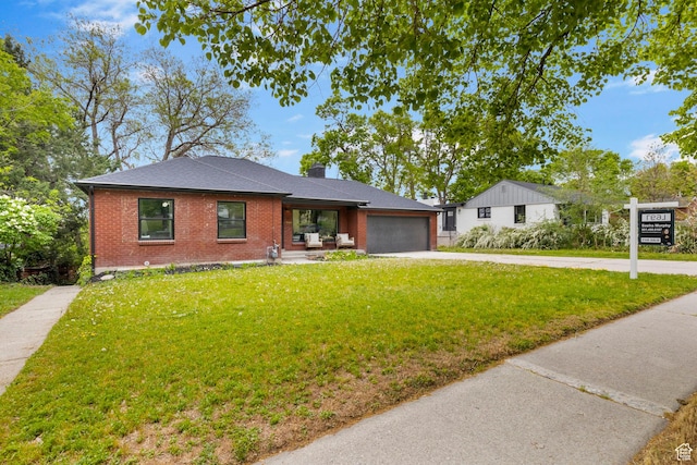 ranch-style house with brick siding, driveway, a garage, a front yard, and a chimney