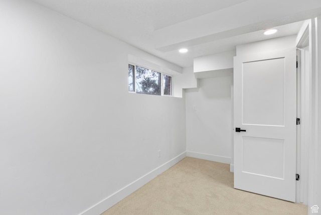 basement featuring light colored carpet, baseboards, and recessed lighting