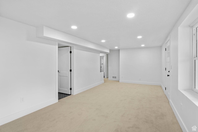 finished basement with light carpet, baseboards, and recessed lighting