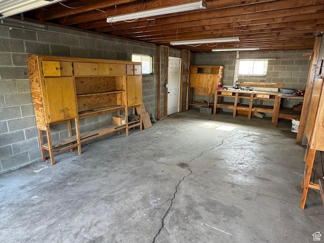 basement with concrete block wall and a workshop area