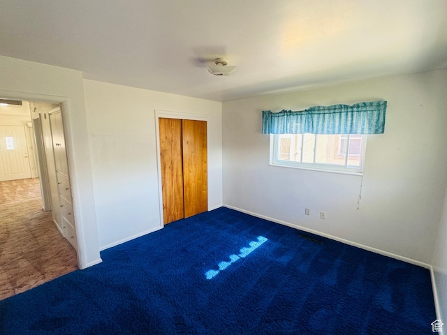 unfurnished bedroom featuring carpet, baseboards, and a closet