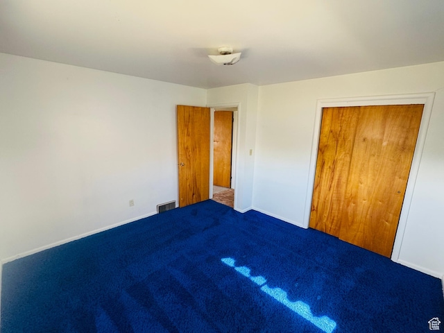 unfurnished bedroom featuring carpet, baseboards, and a closet