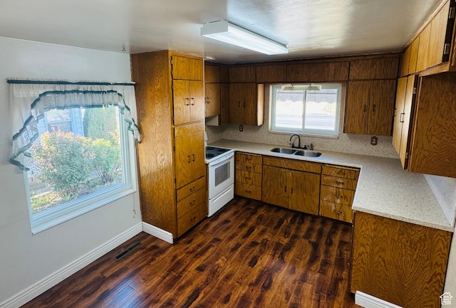 kitchen with white range with electric cooktop, a sink, dark wood-style flooring, brown cabinets, and light countertops