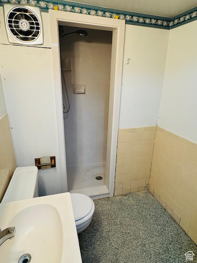bathroom with a stall shower, a sink, and toilet
