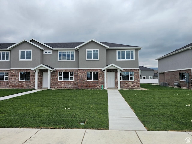 518 N 1400 W Lot 26, Springville, UT 84663 - townhome / multi-family property with brick siding, fence, central air condition unit, stucco siding, and a front lawn