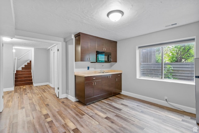 3470 W Maynard Ct, Riverton, UT 84065 - kitchen with visible vents, a sink, black microwave, light countertops, and light wood-type flooring