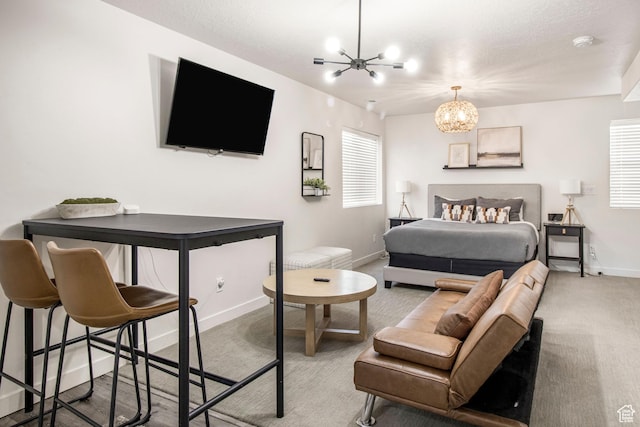 bedroom with an inviting chandelier, baseboards, and carpet floors