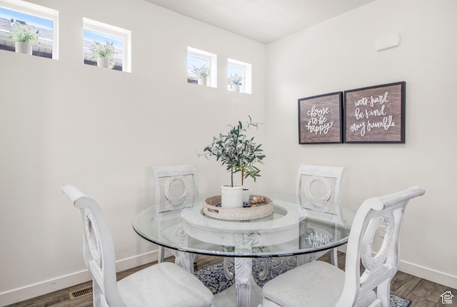 dining space with baseboards and wood finished floors
