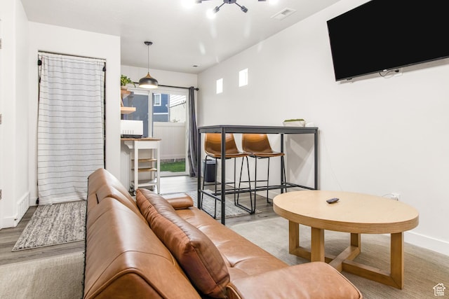 living room featuring wood finished floors, visible vents, and baseboards