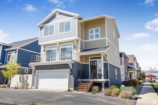 view of front of house with a balcony, a garage, and fence