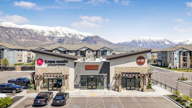 view of building exterior with uncovered parking and a mountain view