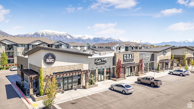 view of building exterior with a mountain view and uncovered parking