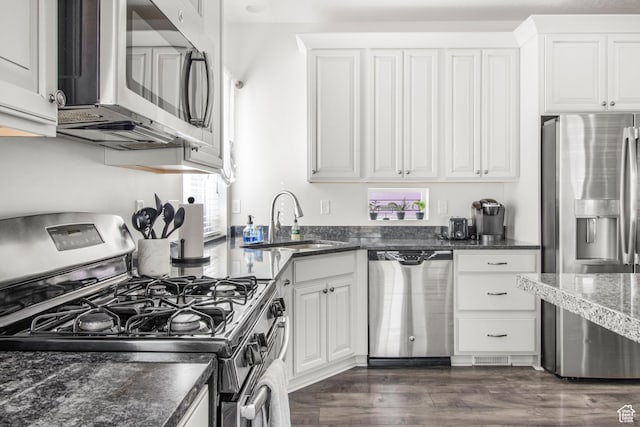 kitchen with a sink, dark wood finished floors, white cabinets, and appliances with stainless steel finishes