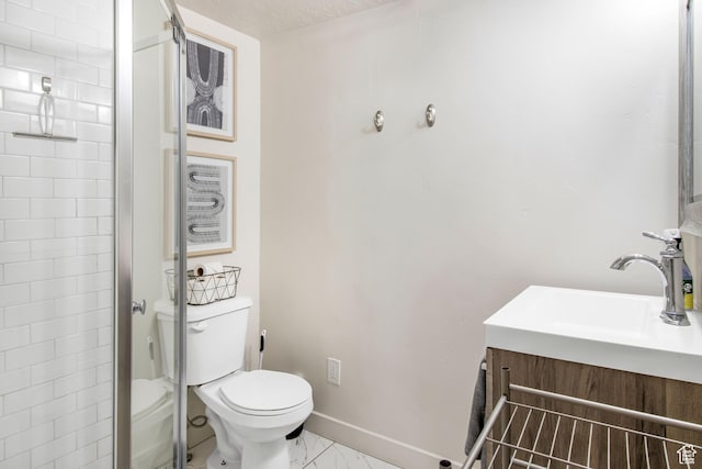 full bathroom featuring toilet, marble finish floor, vanity, an enclosed shower, and baseboards