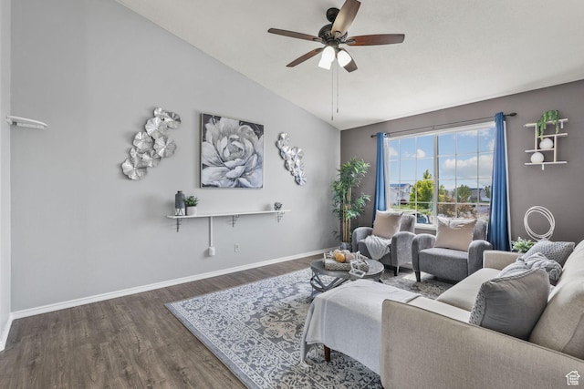 living room with a ceiling fan, vaulted ceiling, baseboards, and wood finished floors