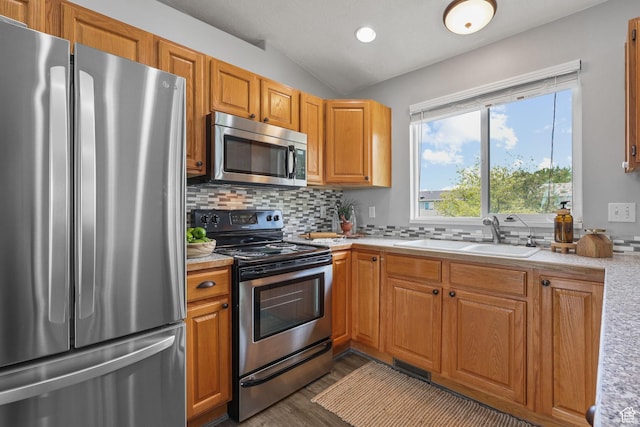 kitchen with stainless steel appliances, light countertops, decorative backsplash, lofted ceiling, and dark wood-style floors
