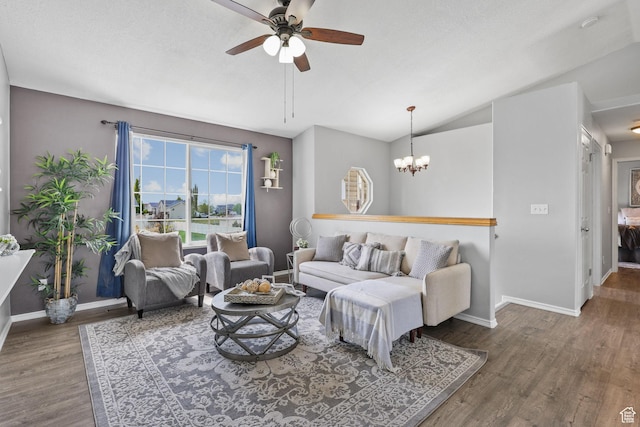 living area with baseboards, wood finished floors, ceiling fan with notable chandelier, and lofted ceiling
