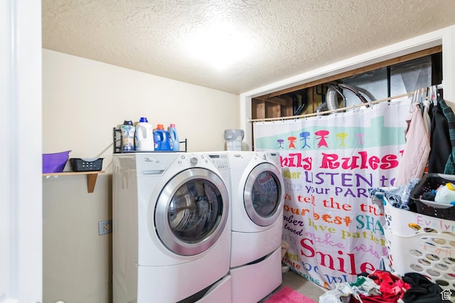 clothes washing area featuring separate washer and dryer, laundry area, and a textured ceiling