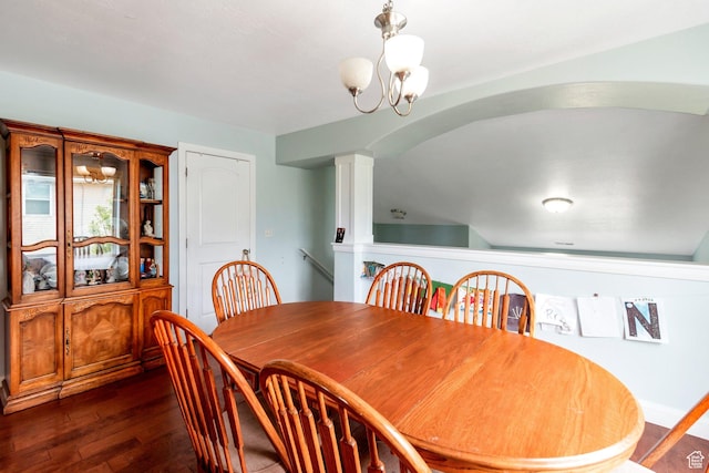 dining room with dark wood-style flooring, an inviting chandelier, and decorative columns