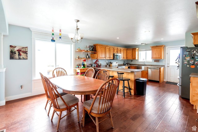 dining space with a wealth of natural light, a notable chandelier, and dark wood-style floors