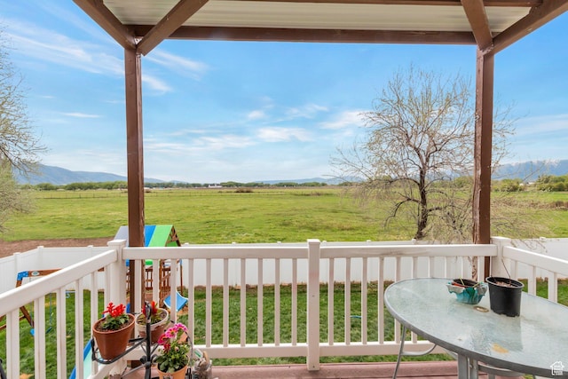deck featuring a yard and a rural view