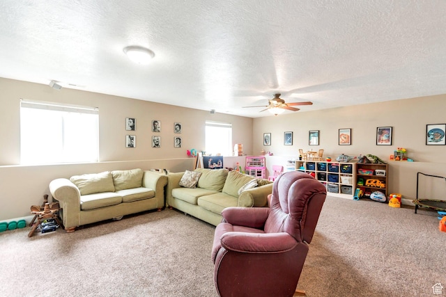 living area featuring light carpet, ceiling fan, and a textured ceiling