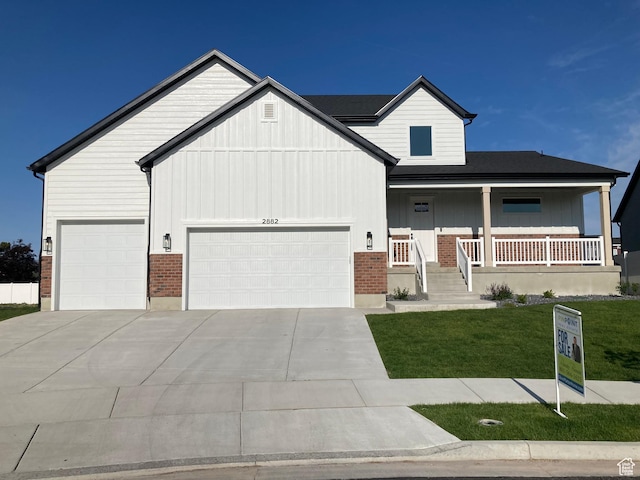 2882 S Allison Way W, Syracuse, UT 84075 - view of front of home featuring an attached garage, a front lawn, board and batten siding, driveway, and brick siding