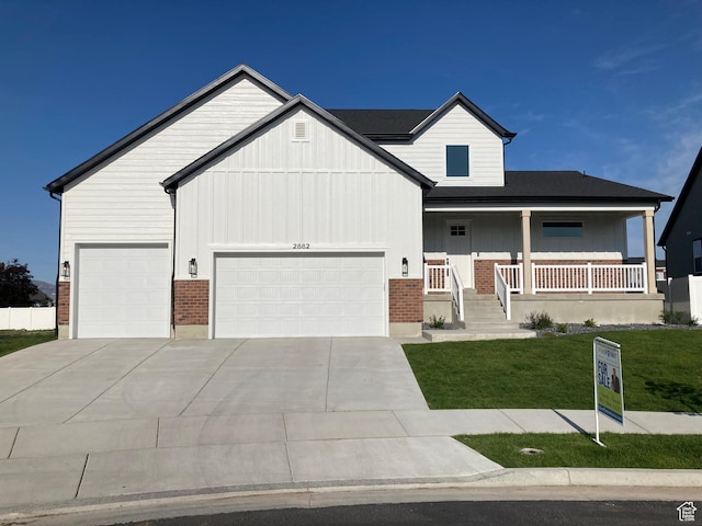 2882 S Allison Way W, Syracuse, UT 84075 - view of front facade with brick siding, a front yard, an attached garage, and concrete driveway