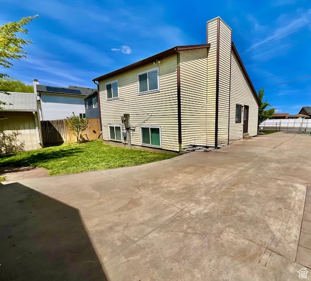 2610 S 8000 W, Magna, UT 84044 - back of house with a yard, fence, a patio, and a chimney