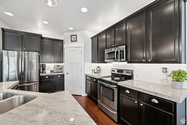 1559 W 430 N, Lindon, UT 84042 - kitchen featuring dark wood-style floors, appliances with stainless steel finishes, decorative backsplash, light stone counters, and recessed lighting