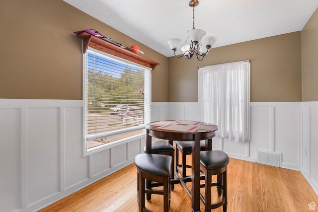 173 W 300 N, Bountiful, UT 84010 - dining room featuring a decorative wall, a chandelier, wainscoting, and light wood-style flooring