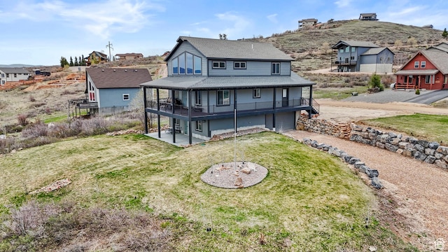 1504 N Sculpin Loop, Garden City, UT 84028 - rear view of house with an attached garage, driveway, a yard, a patio, and a shingled roof