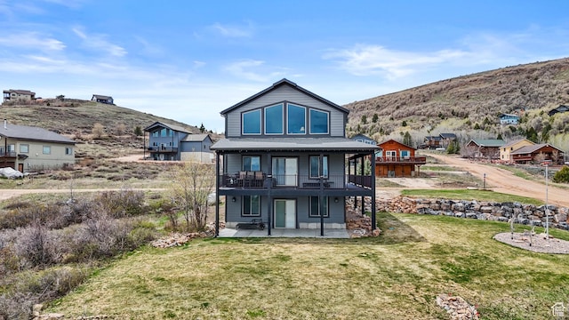 1504 N Sculpin Loop, Garden City, UT 84028 - back of property featuring a yard, a patio area, and a deck with mountain view