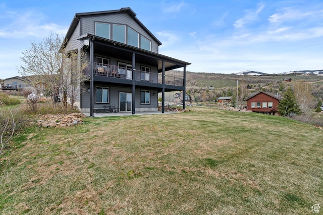 1504 N Sculpin Loop, Garden City, UT 84028 - back of house with a yard, a patio, a mountain view, and a balcony