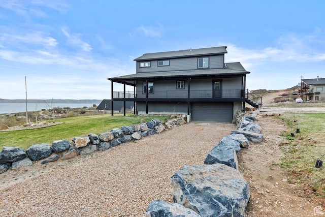 1504 N Sculpin Loop, Garden City, UT 84028 - back of house with a water view, a garage, dirt driveway, a lawn, and stairway