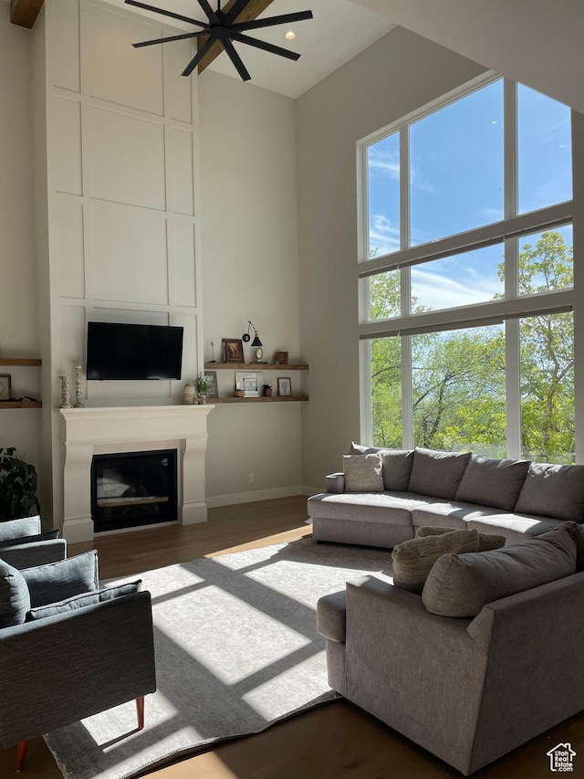 living room featuring a fireplace, wood finished floors, a ceiling fan, baseboards, and recessed lighting