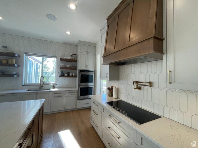 kitchen with open shelves, black electric stovetop, a sink, double oven, and recessed lighting