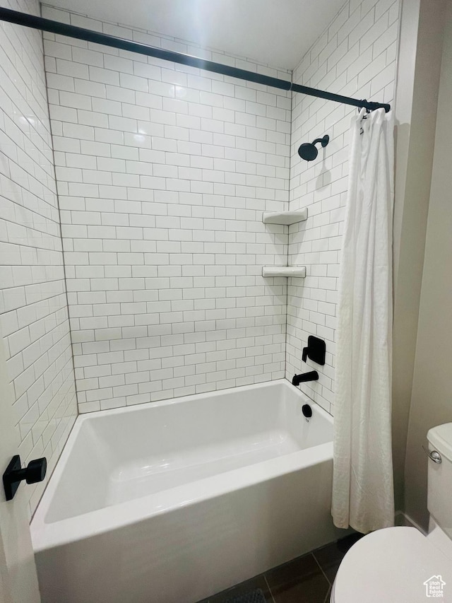 bathroom featuring toilet, shower / tub combo, and tile patterned flooring