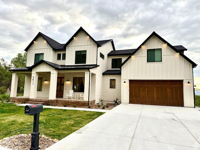 modern farmhouse with a front lawn, board and batten siding, covered porch, and a garage
